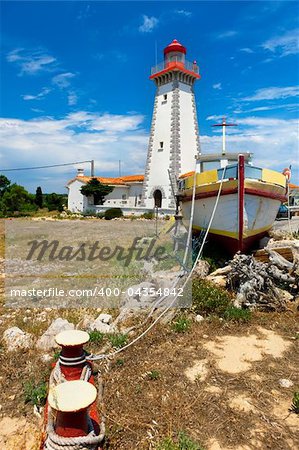 Red and white lighthouse on mediterranean coastline, France