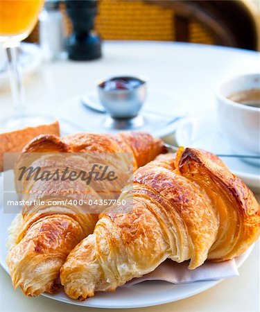 Breakfast with coffee and croissants in a basket on table