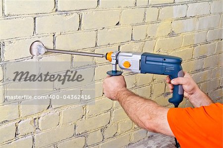 House-builder in uniform working with a plugger.