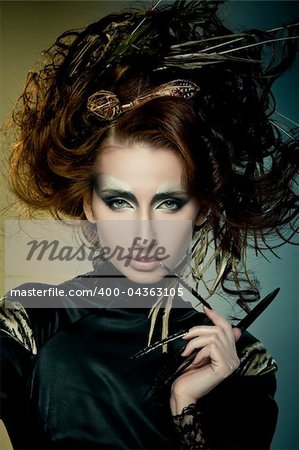 High fashion model in black dress, with long nails and creative hairstyling