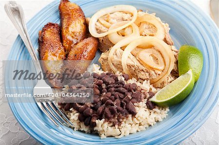 Cuban dinner, consisting of roast pork, black beans and rice, and fried sweet plantains.