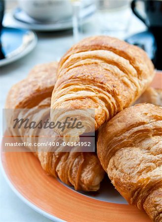 Breakfast with coffee and croissants in a basket on table