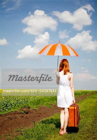 Redhead enchantress walking near rapeseed field.