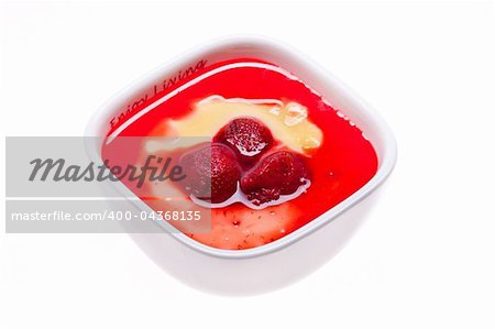 Custard with strawberries in a saucer isolated on white
