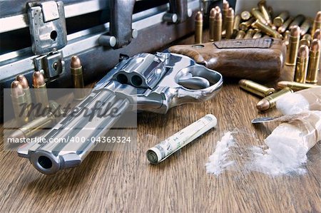 Image concept of drug trafficking. Gun, U.S. dollars, bullets and cocaine on the table.