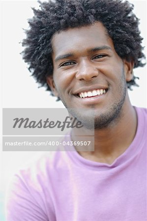 portrait of young african american guy looking at camera near the sea. Vertical shape, head and shoulders