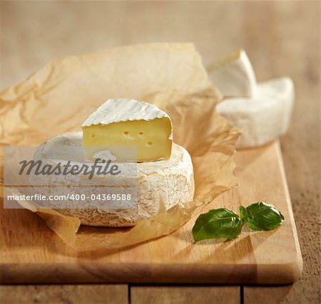 brie and camembert cheese on wooden cutting board