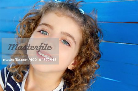 children little girl smiling portrait on wooden blue wall