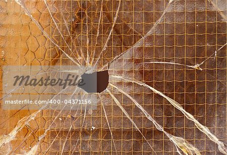 Close up of a broken reinforced glass  cracked with hole