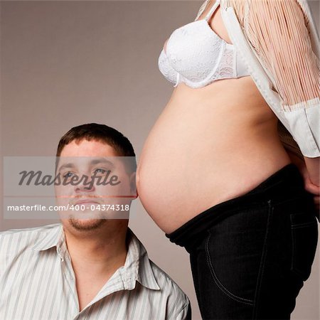 man is trying to listen his baby inside of his pregnant wife