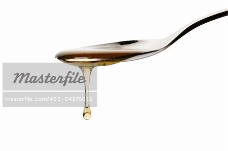 honey drops from a spoon on white background