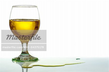 Glass of brandy with some liquid on the table