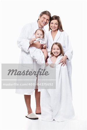 A family with two children in robes on a white background