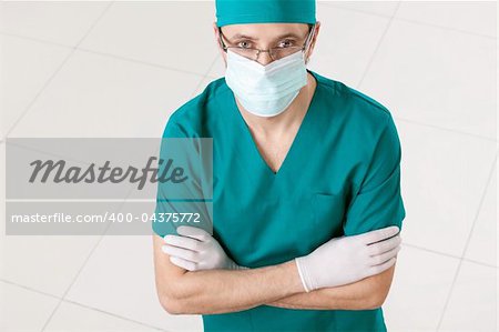 Surgeon in mask and gloves indoors