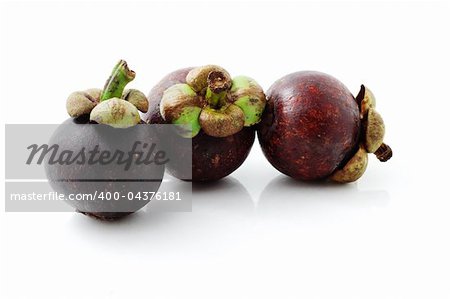 Three fresh mangosteens on white background