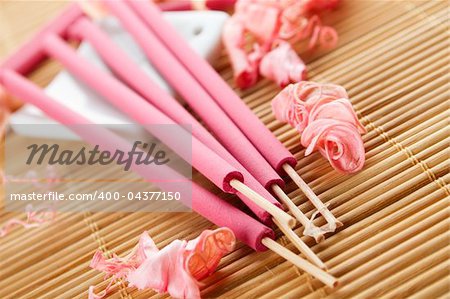 Spa treatment in bright pink and white palette, petals, and arotatizirovannye sticks on a wooden bamboo rug