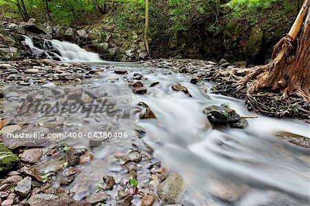 Fast mountain stream with small waterfall