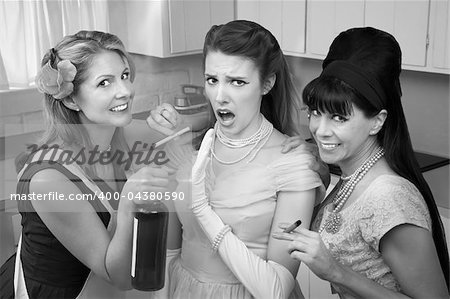 Young woman with her friends smoking and drinking in the kitchen
