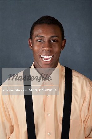 Handsome African-American male on gray background laughs