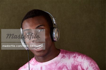 Young African-American male smiles while listening to something on his headphones