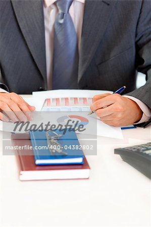 Businessman sitting at office desk and working  with  documents. Closeup.