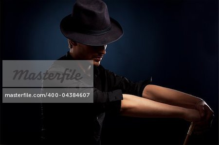 man in a black hat on black background