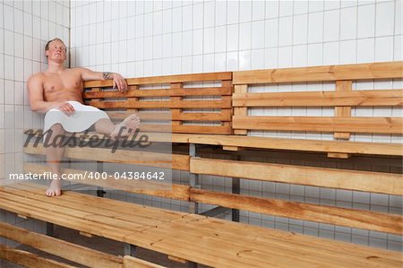 Mature man relaxing in steam room at a sauna spa