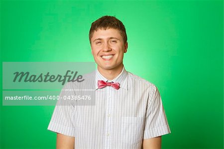 Handsome young man in a shirt with a green background smiling at the camera. "Botanica "
