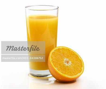 Un verre de jus d'Orange fraîchement pressé avec les fruits sur un fond blanc.