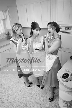 Three women gossiping in a kitchen while smoking cigarettes