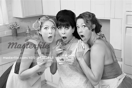 Three surprised middle-aged 1950s retro-style women with cigarettes and tea