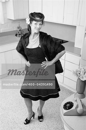 Smiling Caucasian woman in mink coat and hands on hip in a retro kitchen scene