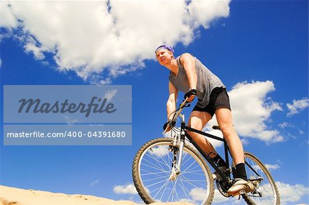 Young men  riding a bike downhill style