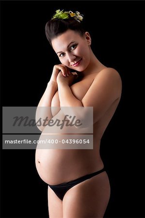 Beautiful young pregnant woman, isolated on black