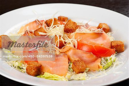 Salad of lettuce, chinese cabbage, tomato, garlic rusk, parmesan cheese, sauce and smoked salmon filet