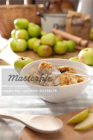 Apple Crumble served in white bowl in a kitchen setting