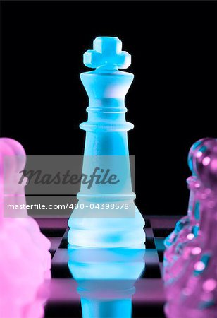 blue queen and rows of purple glass chess pawns is standing on board in dark