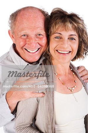 Attractive old couple posing as man hugs his wife from behind, isolated on white background.