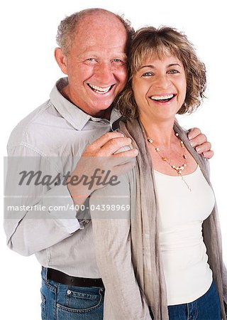 Senior couple posing in studio and smiling at camera.