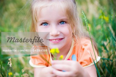 Cute little girl  on the meadow in summer day