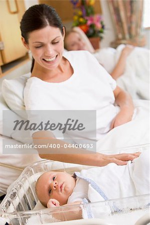 Pregnant mother with baby in hospital smiling