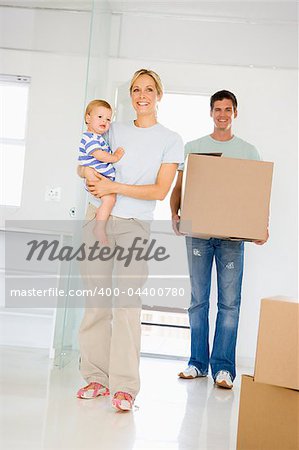 Family with box moving into new home smiling