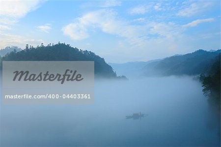 Fishing boat on the foggy river, photo taken in hunan province of China