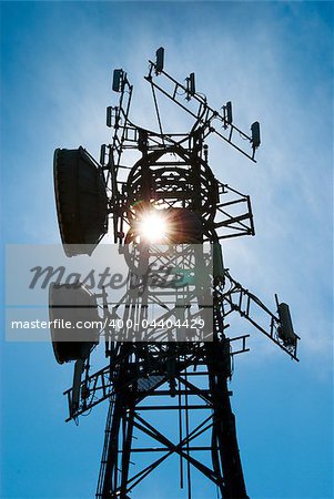 Cellphone antenna tower back lit by sun