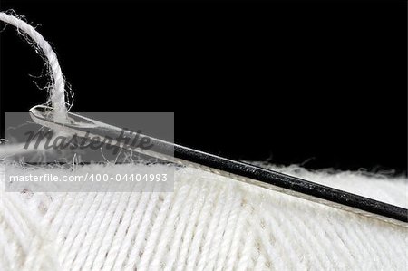 macro shot of needle and thread over black background