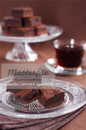 Chocolate brownies on the cake stand and cup of coffee