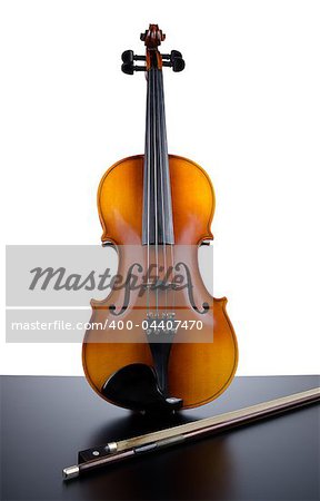 Violin on top of dark table partially isolated on white background.