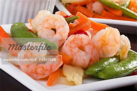 Close-up photograph of a shrimp salad on a white plate.