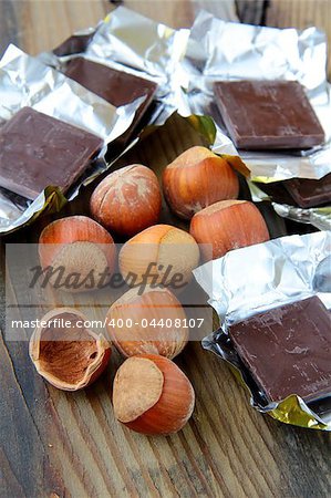 tasty chocolate with hazelnuts on wooden table