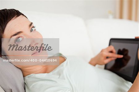 Smiling woman using a tablet computer while looking at the camera